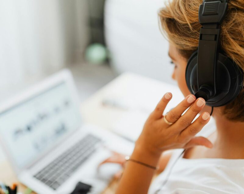 Person in White Shirt Holding Black Headphones